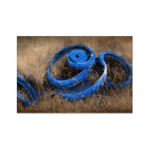 a blue bicycle tire on the side of the road with grass and dirt