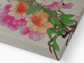 A little green shoe box inside of a wooden box on a cardboard box covered in flower