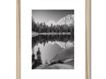 An art photograph set made with a wooden frame on top of framed artwork on a white