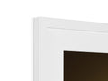 A white picture frame that is on top of a mirror beside a large desk.