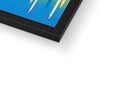 A picture frame with colorful art on it laying beside a laptop computer on top of a