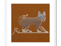 A cat sitting on a small silver and white paper plate decorated with old hieroglyph