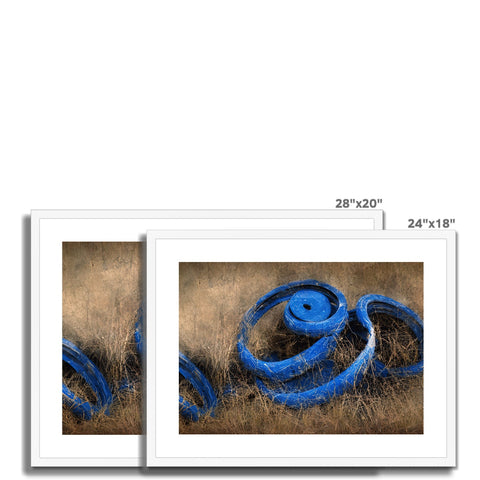 An art print with blue ribbon on it sitting next to some water on a wood floor