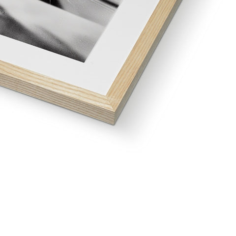 A photo of a person putting a picture in a wooden frame in a white book.