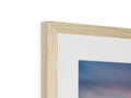 A photo of the beach in the sun hangs on a picture shelf next to a wooden