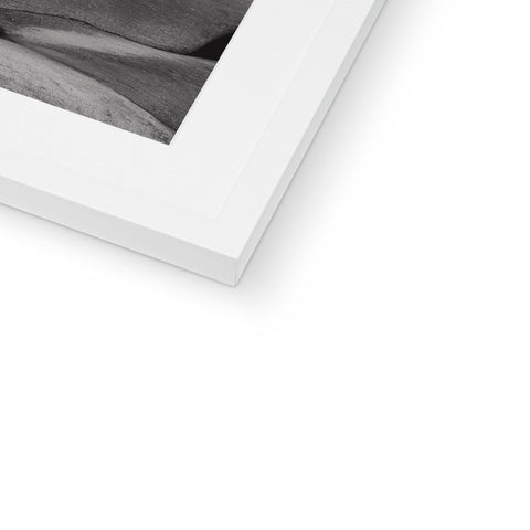 A white photo is placed in a white photo frame on a white frame.