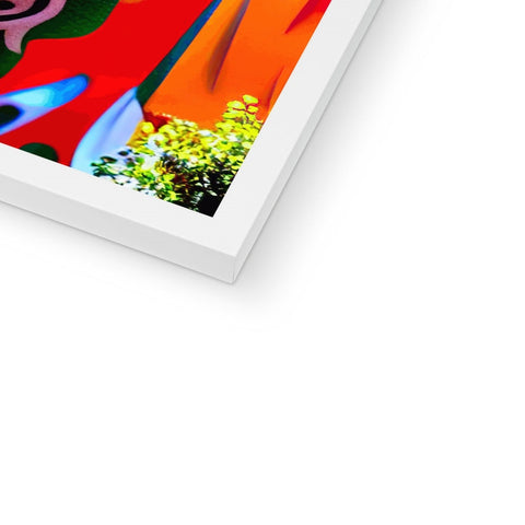 An art print sitting on top of a picture hanging on a shelf with colored background.