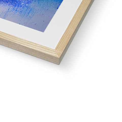 A blue and white print image inside of a wooden frame.