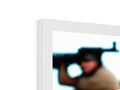 A picture a guy looking at the computer while holding a handgun is framed in a frame