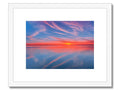 A view of a sunset on the water that is framed with a paper print.