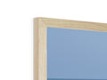 A wooden picture frame is located near a mirror, some picture frames, and a white