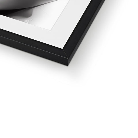 A picture frame of a white wall frame on top of a black mirror.