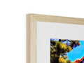 A wooden frame frames a photo sitting on top of a stack of pictures.