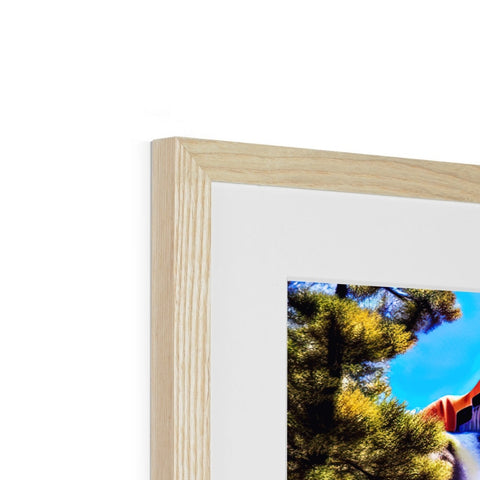 A wooden frame frames a photo sitting on top of a stack of pictures.