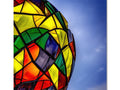 A lamp on top of a light fixture with a colorful colored kite in front of