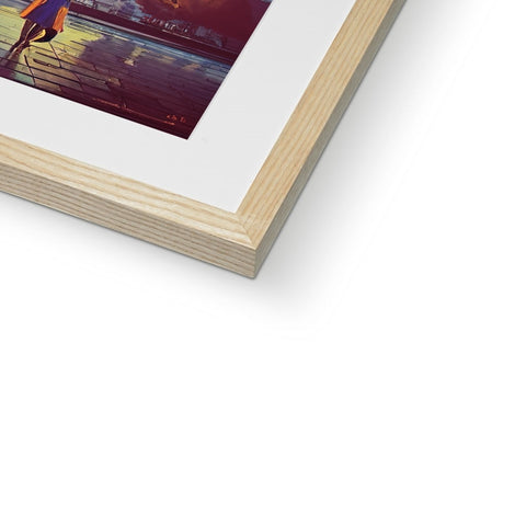 A photo is sitting on top of a wooden frame next to a metal book.