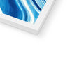 An imac, large picture of an iceberg on a wall next to some books.