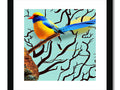 A photo of a colorful and yellow bird sitting on the bottom of a wooden framed artwork