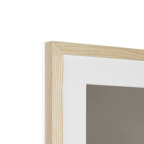 A white picture frame hanging on a wall is surrounded by various different pieces of wood.