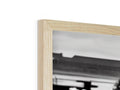 A black and white photo is on a wooden frame with a picture of a photo.