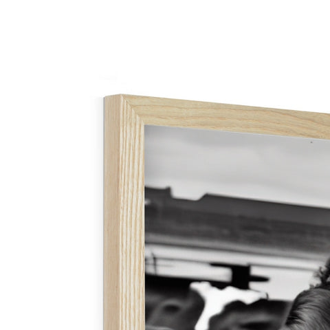 A black and white photo is on a wooden frame with a picture of a photo.