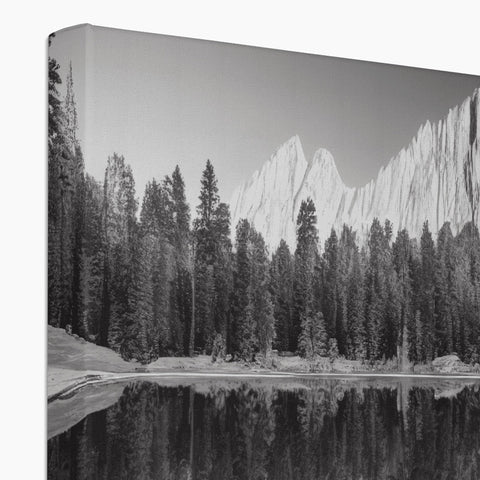 Art print of a mountain and lake next to a fireplace.