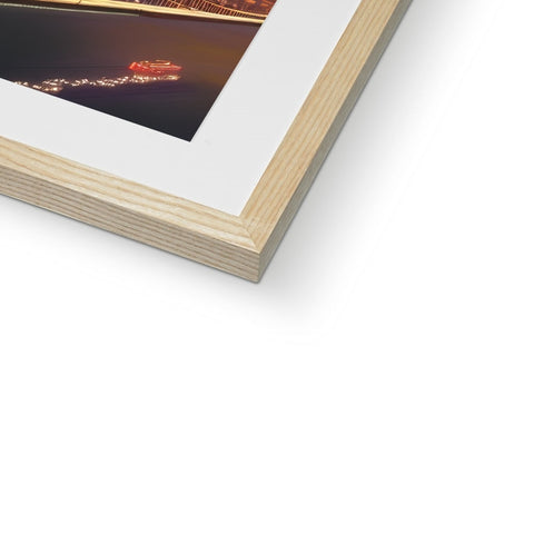 A white photo is attached to a wooden frame on top of a book case.
