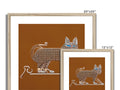 A cat on a wall hanging next to a picture frame for some knick knacks