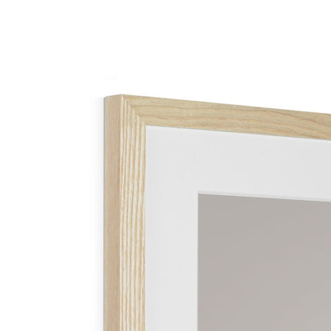 A picture frame has a piece of wood in it above a mirror.