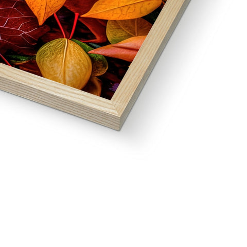 A wooden photo frame with autumn colored leaves on top.