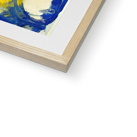 A picture of an abstract painting framed in a white wooden frame on top of a table