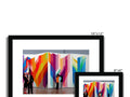 A framed view of a lot of different kinds of color photography on a white wall.