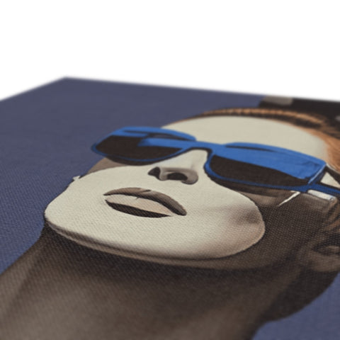 A print of a dark blue sunglasses on a blanket on a table.