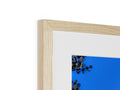 A blue wooden frame with a small picture hanging from the frame.