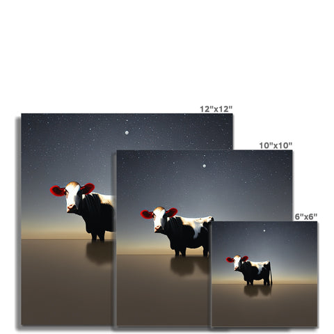 A set of picture calendars with cows sitting on a table.