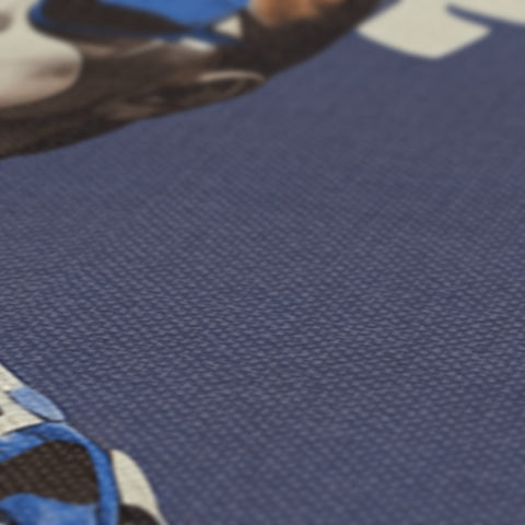 A close up of a blue jersey on a tabletop by a blanket.