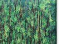 A tree covered forest with green trees in the background with some cattails and a