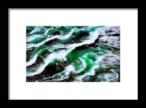 A crashing wave breaks in the sea surrounded by green colored waves