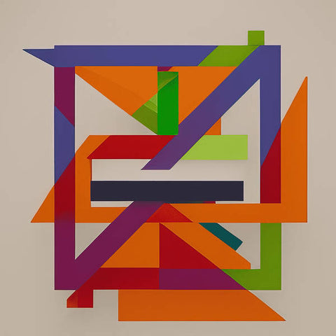 An arrangement of colored cubes next to a square frame of paper.