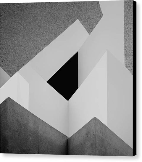 A wall that has a number of vertical triangles with a black and white photograph as it