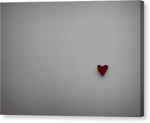 A red heart with a black pillow on top of a white art print