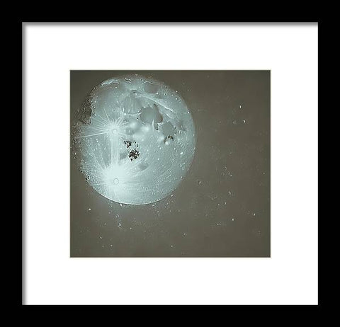 a black and white photo of a full moon holding an art print