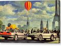 some cars travel through a city while two air balloons flutter by