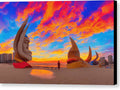 A picture of a sunset surrounded by colorful sculptures on a dark beach
