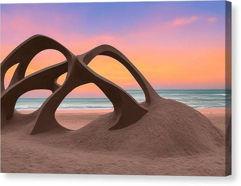 a sunset in the sand near a beach holding an art sculpture