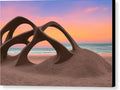 a sunset in the sand near a beach holding an art sculpture