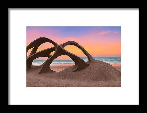An art print sitting on this sand sand at sunset on top of a beach filled with