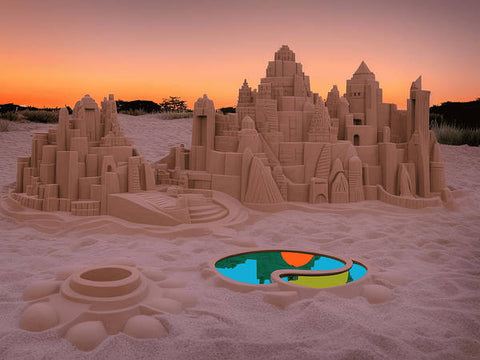 a large colorful sandcastle sit in near the ocean on a sand beach