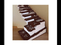 A white tray filled with a bunch of large chocolate cakes standing on top of a white