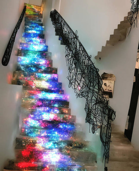 A small room decorated with Christmas lights on a staircase